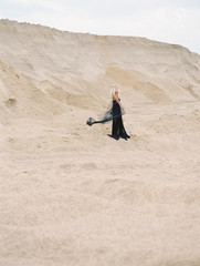 Halloween sexy witch woman portrait, dark dress and bouquet , gold diadem, gothic details, wedding bride style.