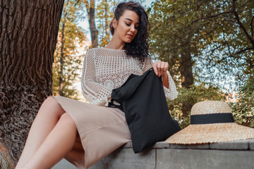 Woman with black blank bag outdoors in park. Place for Empty space. Copy space. Eco friendly.