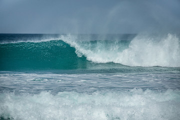 Rolling turquoise surf breaks at Fistral beach in Cornwall