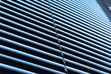 aluminum blinds tightly close window in house from sunny bright daylight