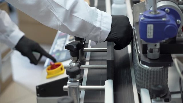 Close look of Scientist working on labeling machine in Hemp Cbd laboratory