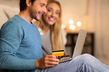 Young Couple Shopping Online Using Laptop And Credit Card At Home