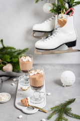 No-baked layered chocolate mousse and cheesecake with marshmallows in clear glasses on gray background. Recipe, creamy dessert, menu, cafe