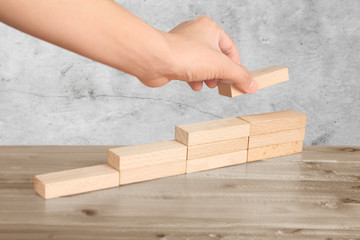 Hand liken person stepping up wood block stacking as step stair