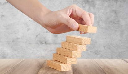 Hand liken person stepping up wood block stacking as step stair