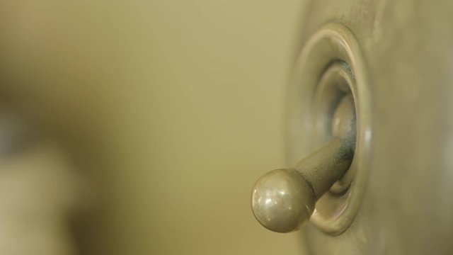 Closeup shot of an old fashioned light switch being flipped