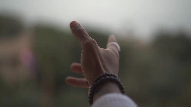extended hand with jewelry and bokeh
