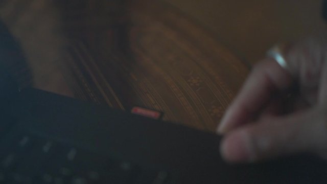 man inserting an sd card into his laptop