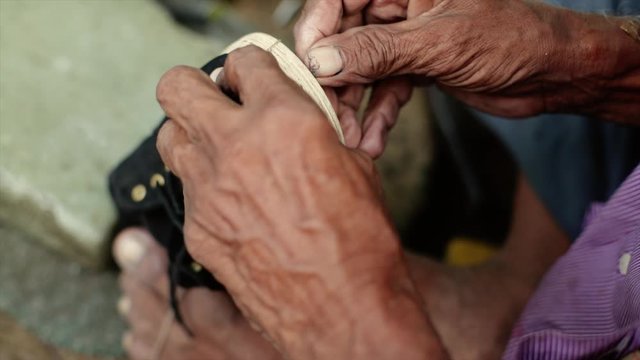 A cobbler repairing slippers of pilgrims by the roadside in the morning stock footage collection 3