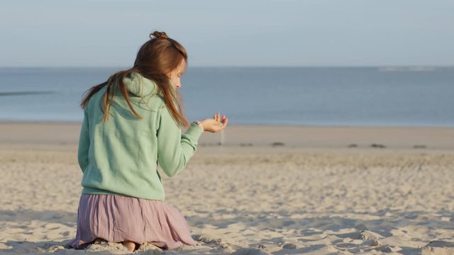 Girl sits on the beach and touches the white soft sand.
4K 12 Bit Apple ProRes file.