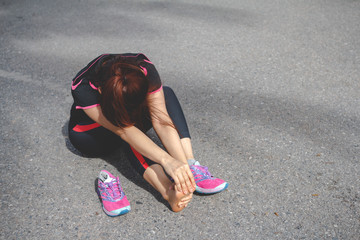 Fototapeta premium Sport woman feeling pain in her foot after running. Injury from workout concept