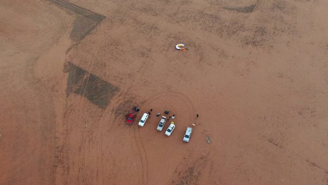 Top down aerial shot of group of parachutist vehicles parked as they prepare for paramotor sport