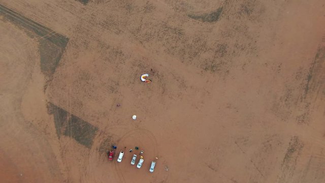 Top down view of group of parachutist park and preparing paramotor to fly in early time
