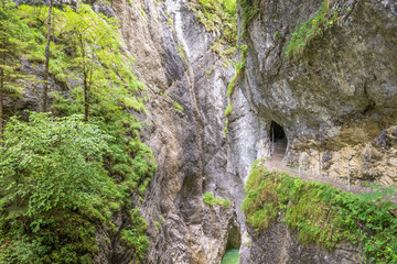 Canyon Kaiserklamm in Austria, hiking trail between steep rocks and green trees