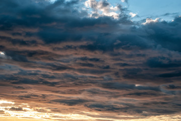 Obraz premium Red and gray thunderclouds against a blue sky