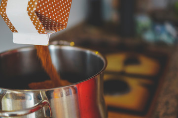 Pouring brown sugar on a casserole