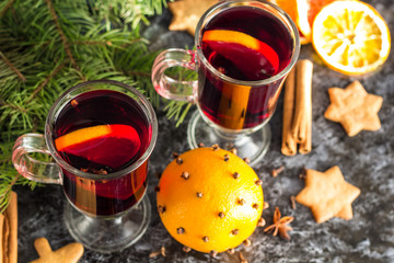 Christmas mulled wine with ginger biscuits orange cinnamon clove anise and fir tree on the dark table