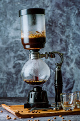 Japanese siphon coffee maker r on old kitchen table background, It is very fragrant and aroma because filled with fresh coffee beans in lighting studio