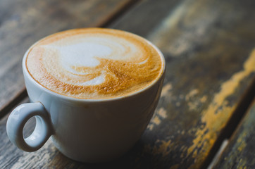 close up modern hot black coffee the cappuccino on wood background with coffee bubble foam pattern and texture in white cup looking and feel so delicious on glasses table in coffee shop.