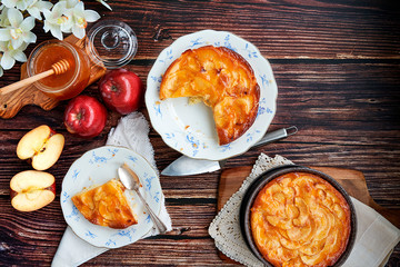 Homemade apple pie bathed with peach jam and honey. White flowers, jar of peach jam and honey....