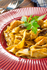 Tagliatelle pasta with chicken and boletus mushrooms.