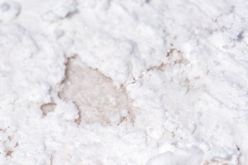 Macro closeup view on white texture of Bonneville salt flats with wet salt on ground abstract