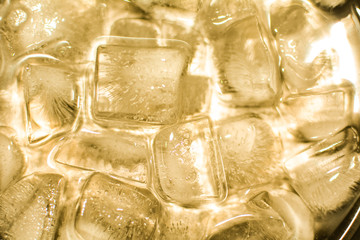 Ice cubes in the light of the yellow lamp