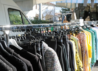 many clothes hanging in the market stall