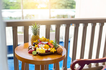 Juicy ripe tropical Thai fruits on a wooden dish.