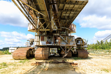 old rusty multi bucket excavator, giant stacker, absetzer in sandy career.
