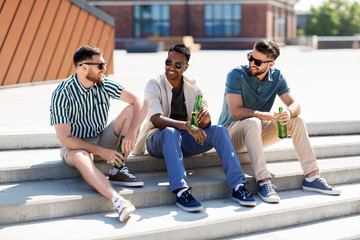 Fototapeta premium leisure, male friendship and people concept - happy men or friends drinking beer and talking on street in summer