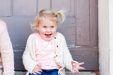 Portrait of happy blonde toddler girl expressing joy