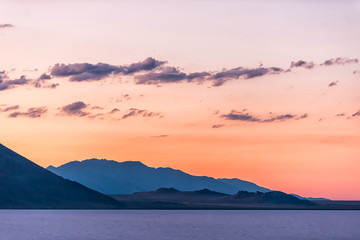 Bonneville Salt Flats colorful purple red twilight silhouette mountain view after sunset near Salt Lake City, Utah with clouds