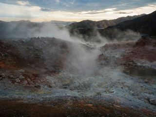 Geothermal fumarole and colorful Rhyolit mountain with multicolored volcanos. Sunrise in Landmannalaugar at Fjallabak Nature Reserve, Highlands Iceland