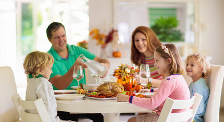 Obraz na płótnie Canvas Family with kids at Thanksgiving dinner. Turkey.