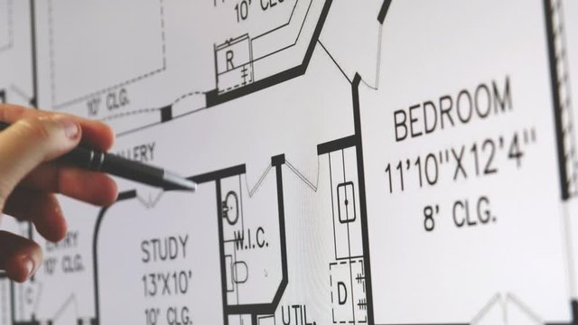 blueprint monitor hand pen explain plan of residential home apartment building on screen