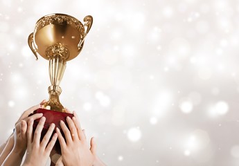 Hand holding golden trophy on blurred background