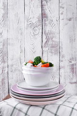 Light salad with broccoli, cherry tomatoes and feta cheese in a white ceramic bowl