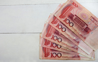 100 yuan on a white, wooden background. View from above. Chinese money.