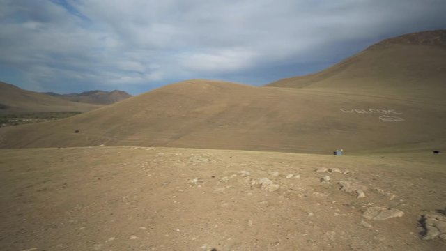 Pan: Village by rocky mountains with welcome text on landscape against sky - Ulaanbaatar, Mongolia
