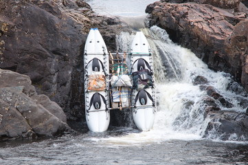 Inflatable catamaran descends down a waterfall.