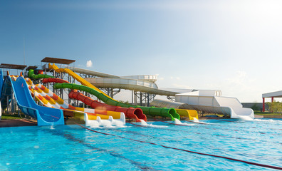 Water park, bright multi-colored slides with a pool. A water park without people on a summer day...