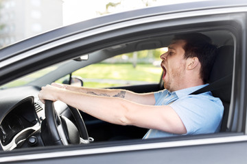 transport, vehicle and driving concept - tired sleepy man or car driver yawning