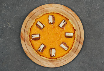  pumpkin pie on a wooden board on a dark gray background. halloween treat.