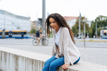 Fototapeta premium Trendy young woman sitting on an urban bridge