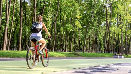 Leisure. Girl rides a bicycle in the park.
