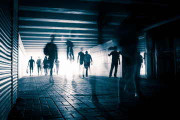 People silhouettes in the pedestrian tunnel.