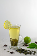 glass of water with lemon with green lime on white background