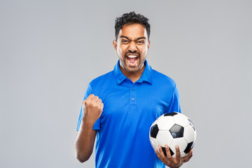 sport, leisure games and success concept - happy indian man or football fan with soccer ball...