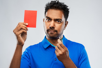 sport, caution, game and football concept - indian male referee with whistle and showing red...